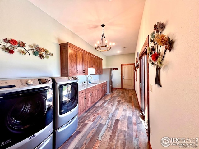 washroom with sink, independent washer and dryer, dark hardwood / wood-style flooring, cabinets, and a chandelier