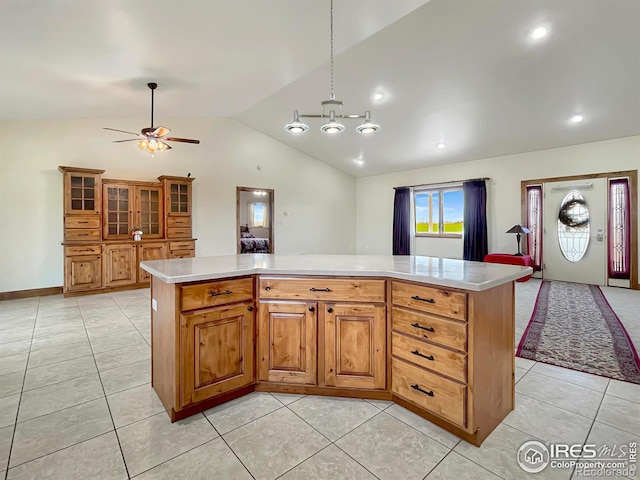 kitchen with vaulted ceiling, ceiling fan, decorative light fixtures, a center island, and light tile patterned flooring