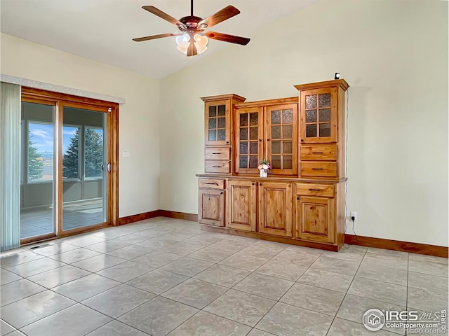 unfurnished dining area featuring vaulted ceiling, ceiling fan, and light tile patterned flooring