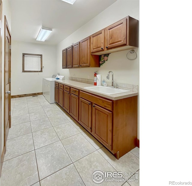 1241 S Sherman Ave, Holyoke, CO 80734 - kitchen featuring independent washer and dryer, light tile patterned floors, brown cabinetry, a sink, and light countertops