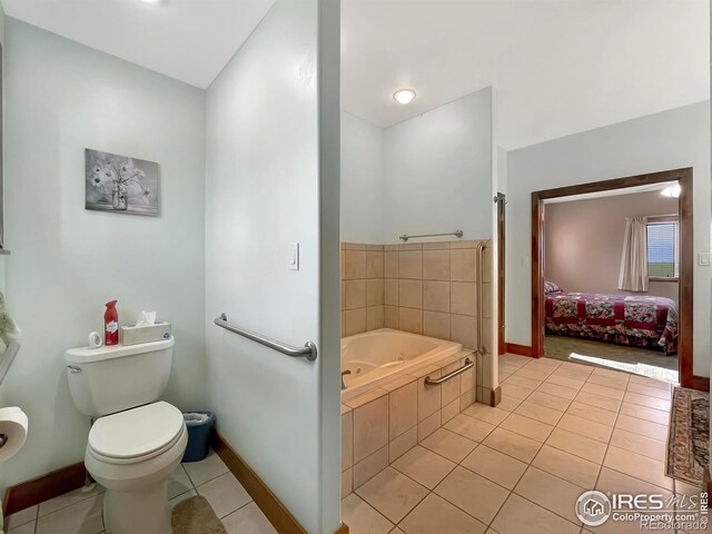 bathroom with tile patterned floors, tiled bath, and toilet