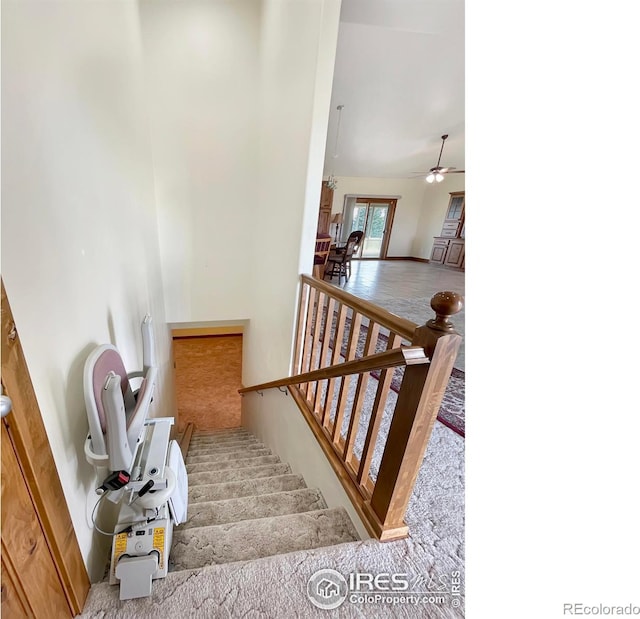 stairway with carpet flooring, ceiling fan, and high vaulted ceiling