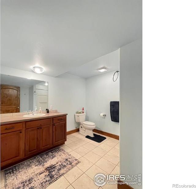 bathroom with tile patterned flooring, vanity, and toilet