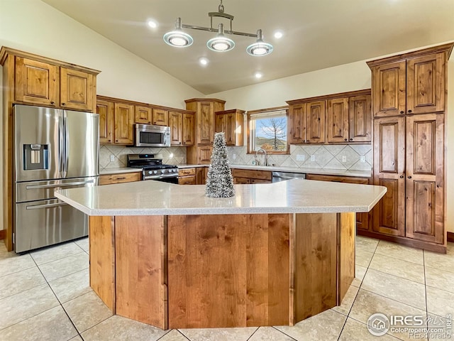 kitchen with stainless steel appliances, a spacious island, hanging light fixtures, lofted ceiling, and light tile patterned flooring