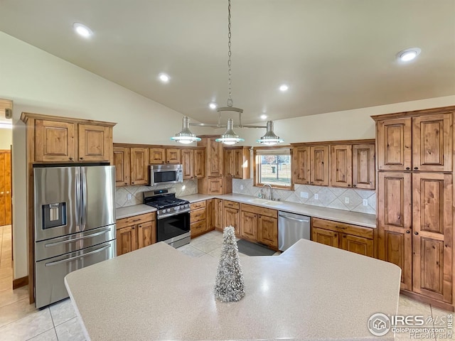 kitchen with stainless steel appliances, vaulted ceiling, sink, light tile patterned floors, and hanging light fixtures