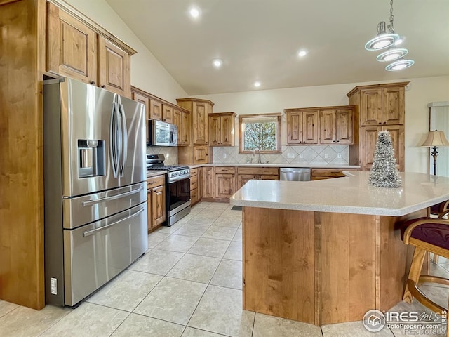 kitchen with decorative backsplash, appliances with stainless steel finishes, sink, decorative light fixtures, and lofted ceiling