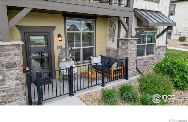 6634 Crystal Downs Dr Unit 104, Windsor, CO 80550 - property entrance with stone siding, a standing seam roof, metal roof, and a balcony