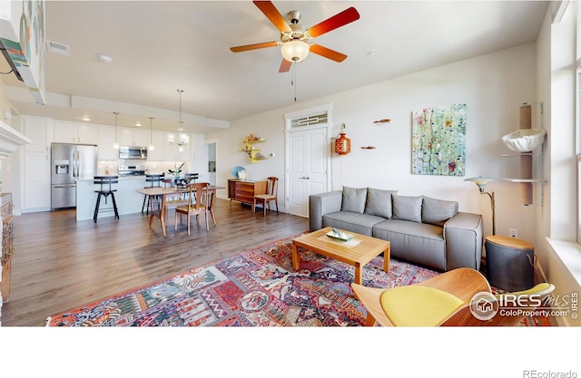 living room with hardwood / wood-style flooring and ceiling fan