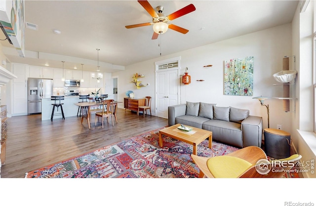 6634 Crystal Downs Dr Unit 104, Windsor, CO 80550 - living room featuring a ceiling fan and wood finished floors