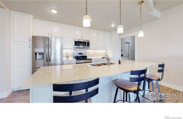 6634 Crystal Downs Dr Unit 104, Windsor, CO 80550 - kitchen featuring stainless steel appliances, a sink, baseboards, light wood finished floors, and recessed lighting