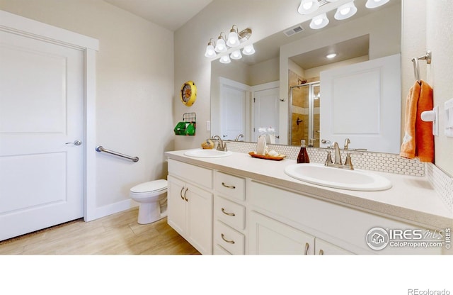6634 Crystal Downs Dr Unit 104, Windsor, CO 80550 - bathroom featuring a stall shower, double vanity, toilet, and wood finished floors