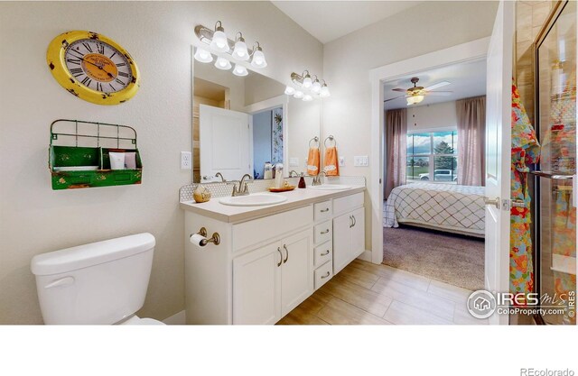 bathroom featuring vanity, toilet, and ceiling fan