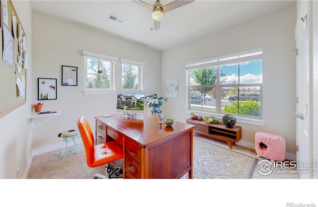 office area with light carpet, a healthy amount of sunlight, and ceiling fan