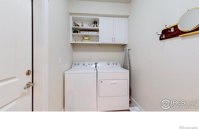 washroom with cabinets and washer and dryer