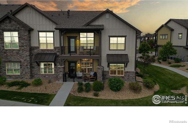6634 Crystal Downs Dr Unit 104, Windsor, CO 80550 - view of front of property featuring board and batten siding, a balcony, stone siding, and a standing seam roof