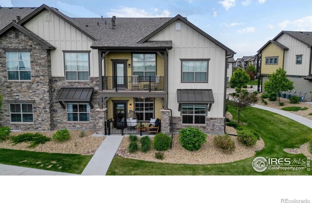 6634 Crystal Downs Dr Unit 104, Windsor, CO 80550 - view of front of property featuring board and batten siding, stone siding, and a standing seam roof
