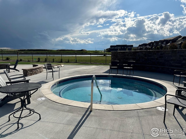 view of pool featuring a hot tub and a patio area