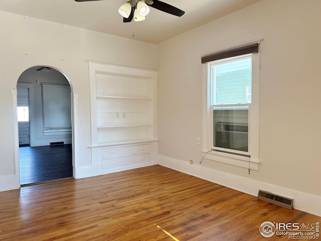 spare room featuring cooling unit, hardwood / wood-style floors, and ceiling fan