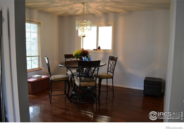 dining space featuring dark hardwood / wood-style floors and a chandelier