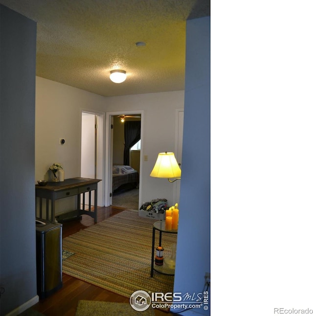 hall featuring dark hardwood / wood-style floors and a textured ceiling