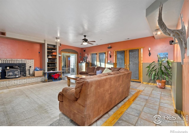 living room featuring french doors, ceiling fan, and built in shelves