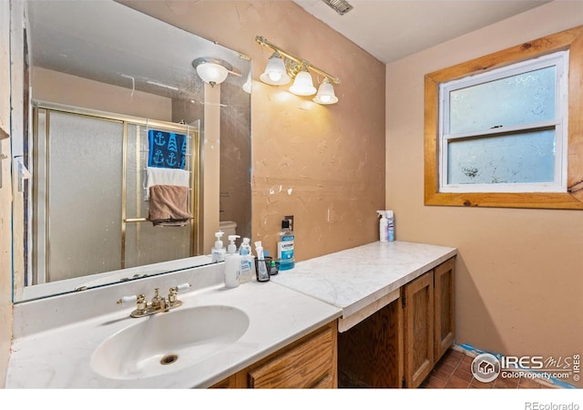 bathroom featuring toilet, walk in shower, vanity, and tile patterned flooring