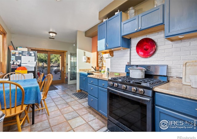 kitchen featuring blue cabinets, tasteful backsplash, and gas range