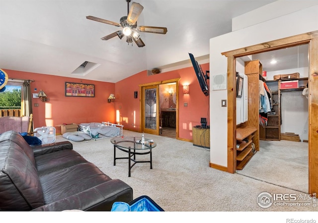 carpeted living room with ceiling fan and vaulted ceiling