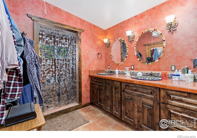 bathroom featuring a shower with door, tile patterned flooring, and vanity