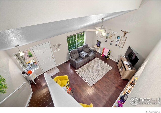 living room featuring ceiling fan, vaulted ceiling, and dark hardwood / wood-style floors