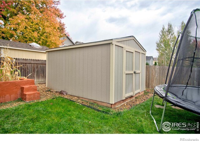 view of outbuilding with a yard and a trampoline