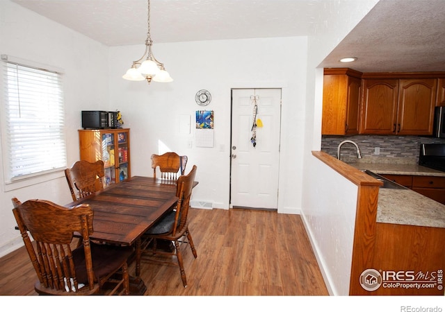 dining space featuring an inviting chandelier and light hardwood / wood-style flooring