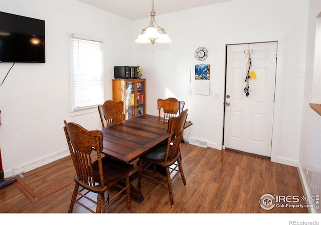 dining room with a notable chandelier and dark hardwood / wood-style flooring