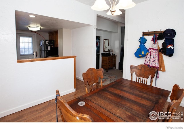 dining area with sink, hardwood / wood-style floors, and a chandelier