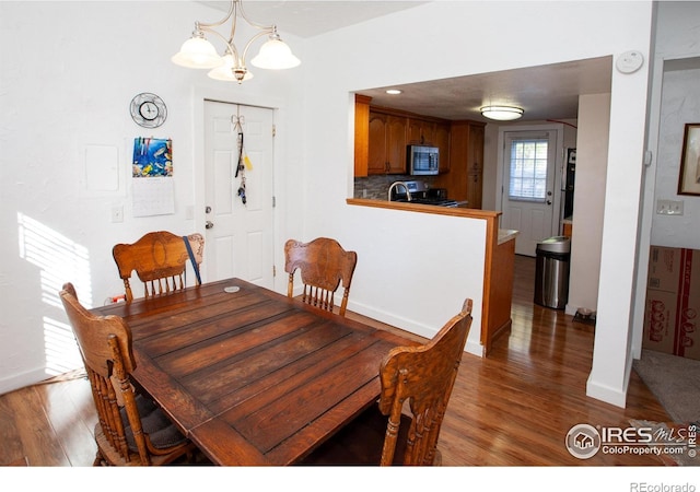 dining space with a chandelier and wood-type flooring