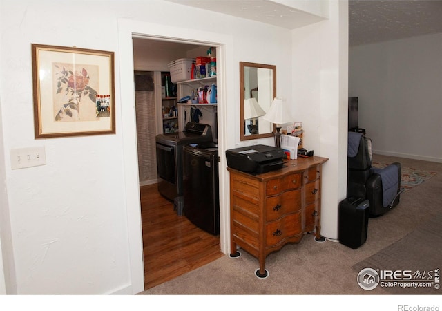 corridor featuring hardwood / wood-style flooring, a textured ceiling, and separate washer and dryer