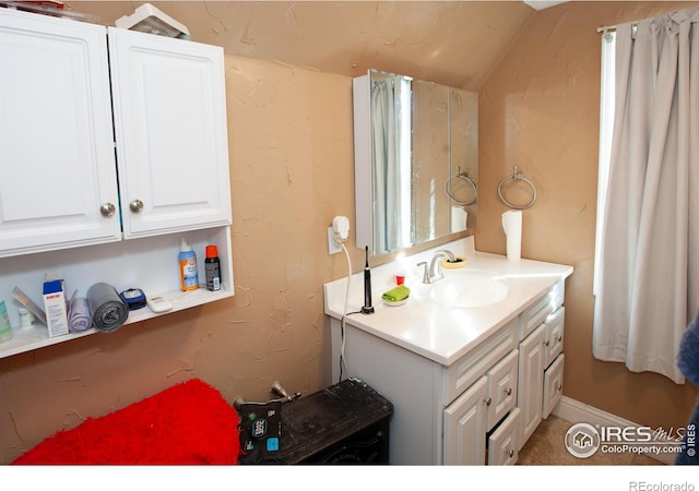 bathroom featuring vanity and lofted ceiling