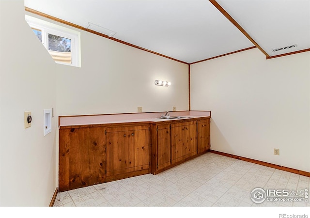 interior space with cabinets, ornamental molding, sink, and washer hookup