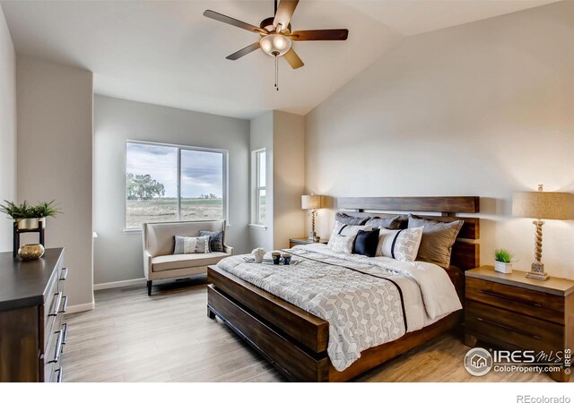 bedroom featuring lofted ceiling, light wood-style floors, ceiling fan, and baseboards