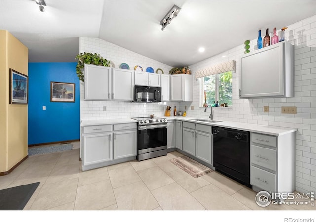 kitchen with lofted ceiling, gray cabinetry, sink, black appliances, and light tile patterned floors