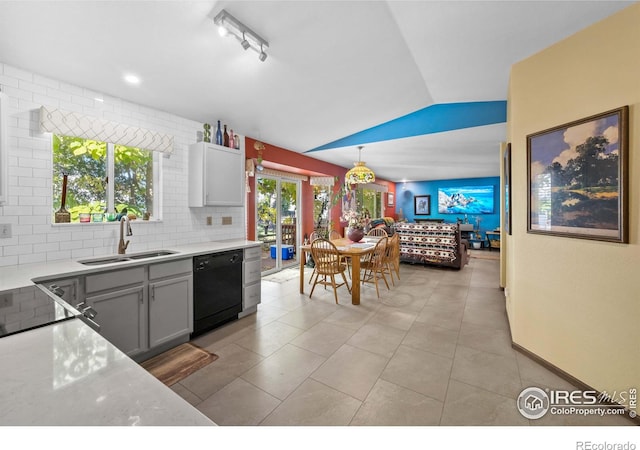 kitchen with dishwasher, hanging light fixtures, gray cabinetry, sink, and vaulted ceiling