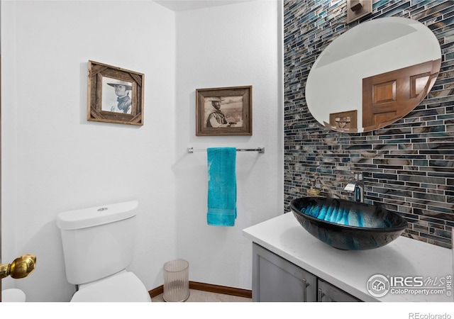 bathroom with toilet, tasteful backsplash, and vanity