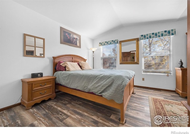 bedroom with vaulted ceiling and dark hardwood / wood-style flooring