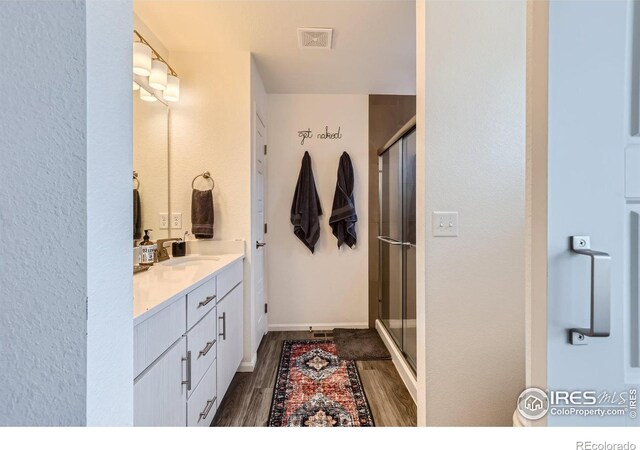 bathroom with vanity, hardwood / wood-style flooring, and walk in shower