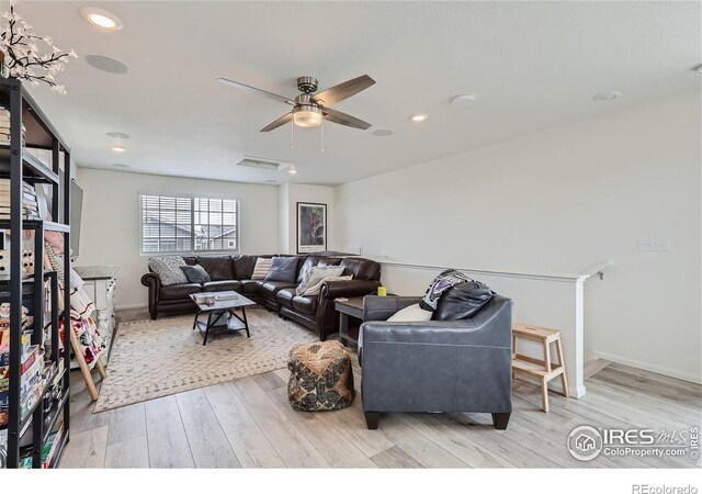 living room with light hardwood / wood-style floors and ceiling fan