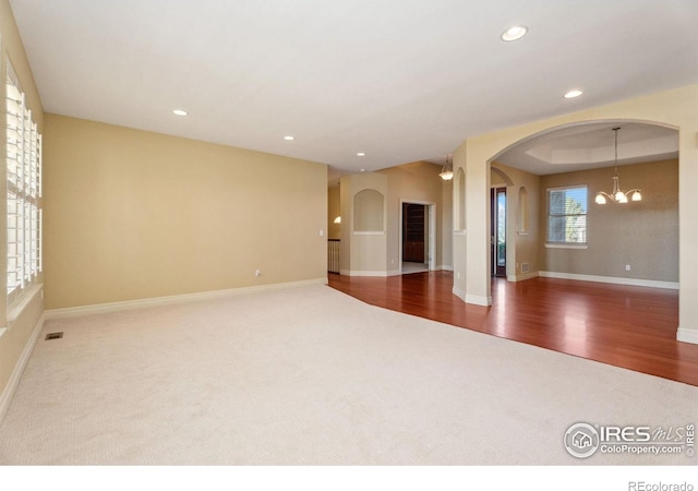 empty room featuring a chandelier and dark hardwood / wood-style flooring