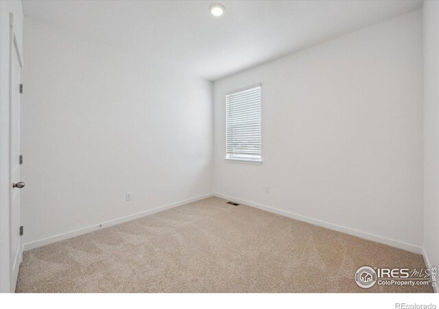 unfurnished room featuring visible vents, baseboards, and carpet flooring