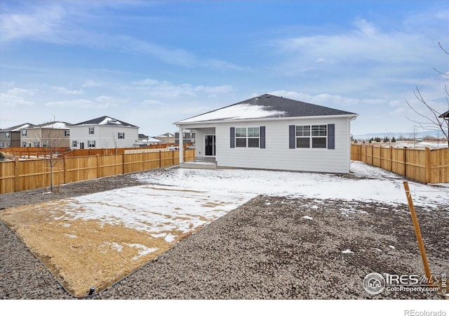 snow covered property with a patio area and a fenced backyard