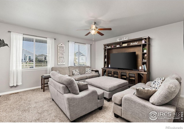 carpeted living room featuring ceiling fan and a textured ceiling