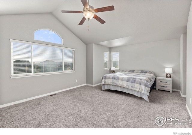 bedroom with carpet, ceiling fan, vaulted ceiling, and multiple windows